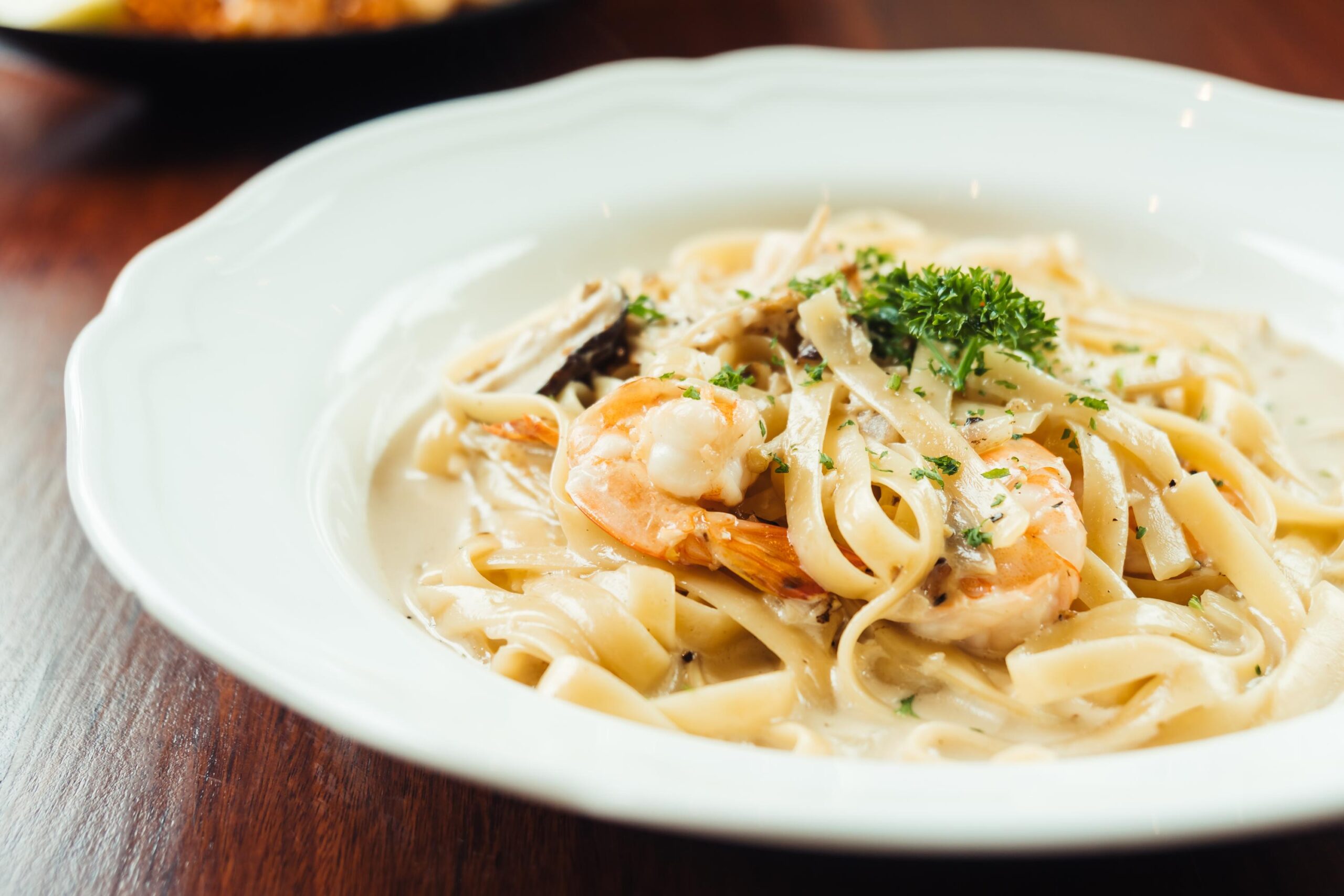 Creamy fettuccine Alfredo sauce recipe served on an elegant plate in a luxury restaurant setting
